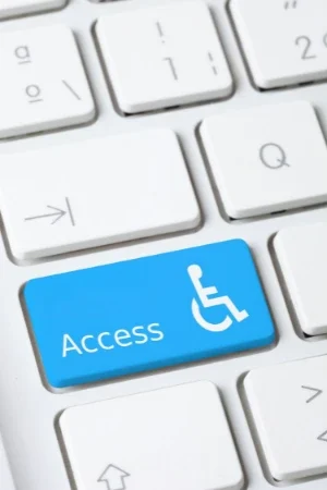 Bild på tangentbord med blå tangent som har en handikappsymbol för att symbolisera tillänglightesanpassad med texten access